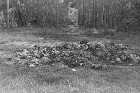 The personal effects of prisoners killed by the Germans lie in a pile on the grass in the Maly Trostinets